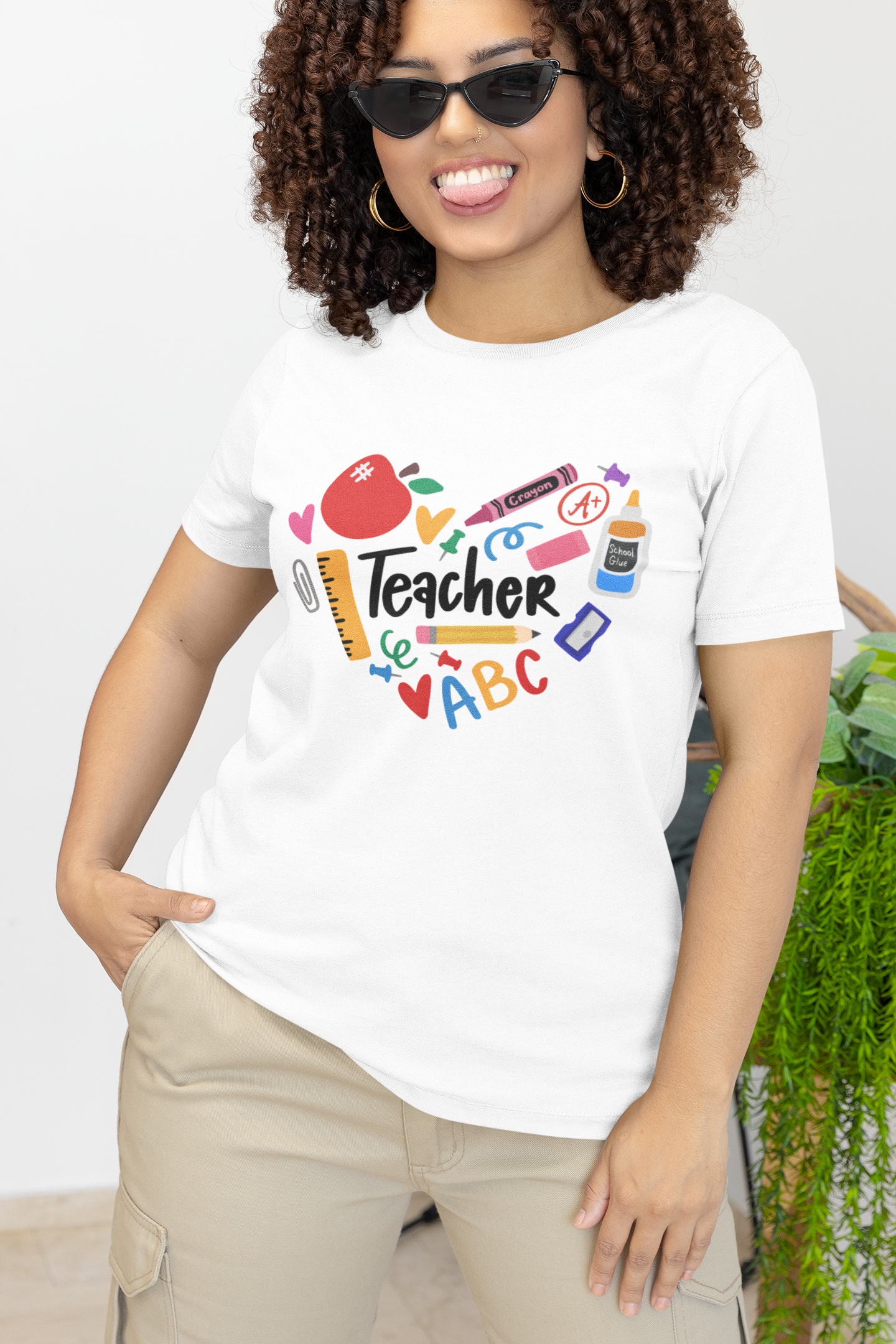 White T-shirt with 'Teacher' graphic, featuring colorful school supplies such as crayons, ruler, apple, and more