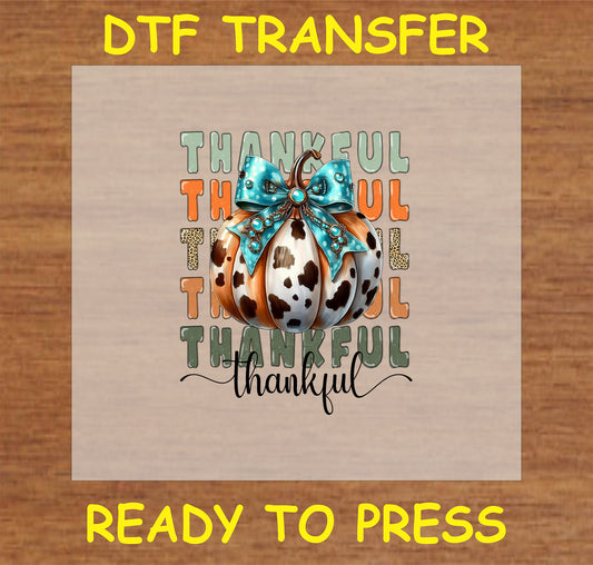 "Thankful Cow Print Pumpkin DTF Transfer with cow print pumpkin, turquoise bow, and 'Thankful' text for rustic Thanksgiving decor"