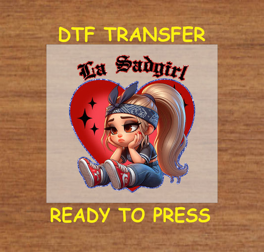 “La Sadgirl” ready to press DTF transfer! This cute design features the text "La Sadgirl" with sad Chicano character with a red heart accent.