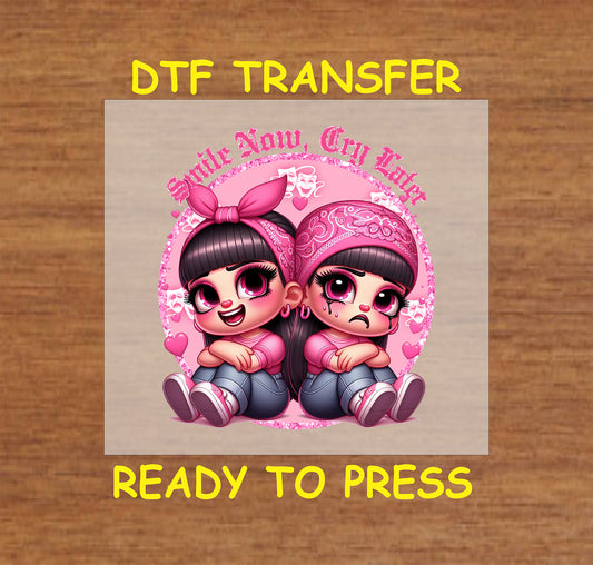 “Smile Now, Cry Later” ready to press DTF transfer! This funny design features the text "Smile Now, Cry Later" with two Chicano characters with pink accents.