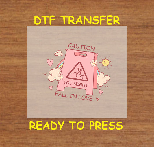 Retro design with "Caution You Might Fall in Love" sign, surrounded by hearts, rainbow, and clouds, ready-to-press DTF transfer.