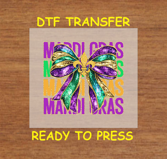 DTF transfer featuring a glittery bow in purple, green, and gold with a fleur-de-lis centerpiece and vibrant "Mardi Gras" text background.