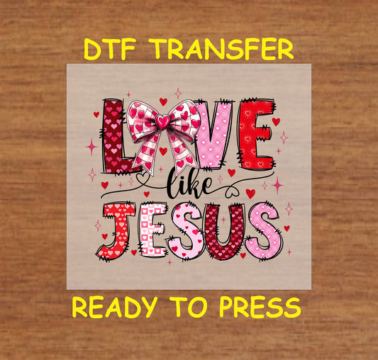 DTF transfer with "Love Like Jesus" Valentine's Day design featuring heart patterns, a pink bow, and bold letters.