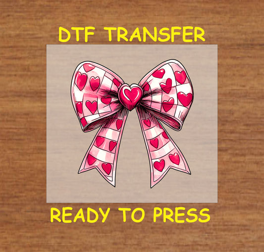 DTF transfer design featuring a pink bow decorated with heart patterns, perfect for Valentine's Day crafts and gifts.