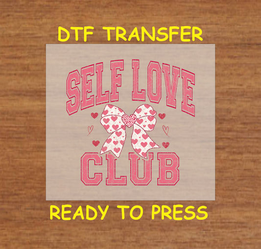 Celebrate self-love this Valentine's Day with this charming "Self Love Club" DTF transfer! Featuring a stylish varsity-style font paired with a heart-patterned bow, this ready-to-press design is perfect for anyone embracing self-care and love.