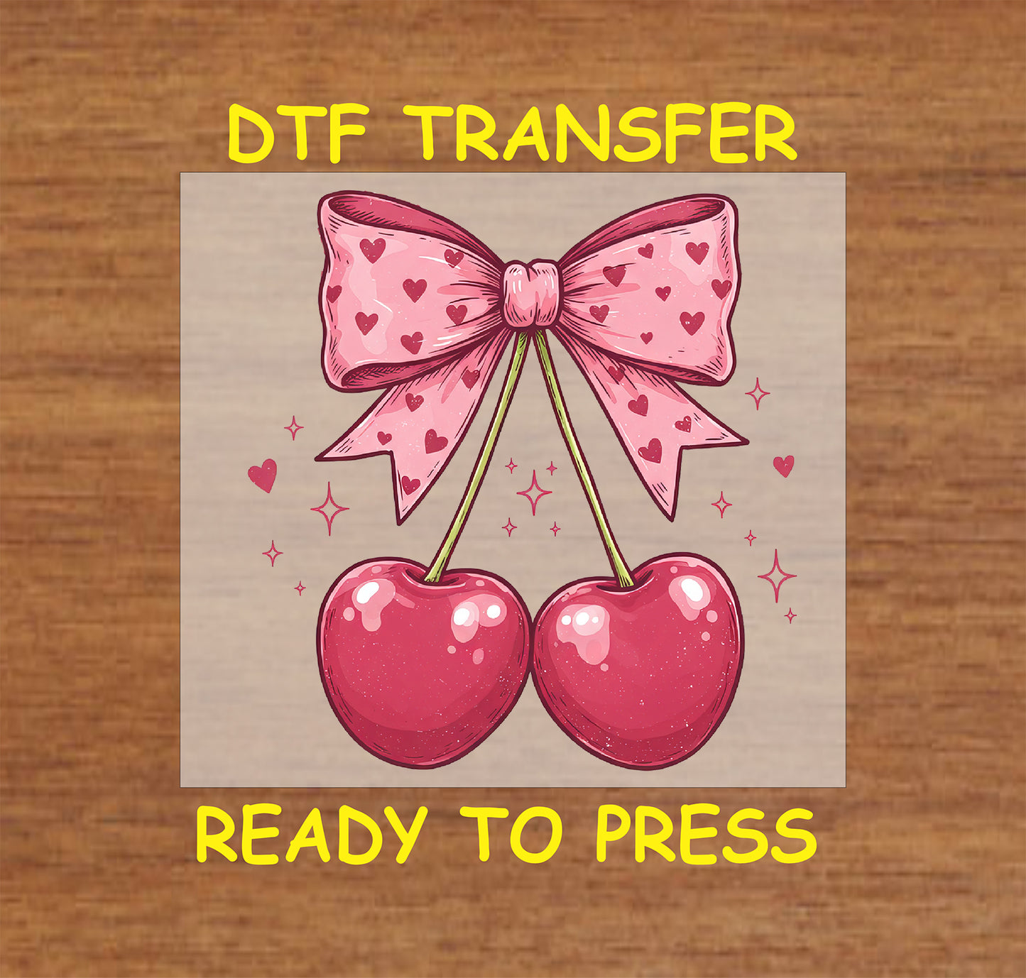 DTF transfer featuring two glossy red cherries tied with a pink bow adorned with heart patterns, surrounded by small heart and sparkle accents.