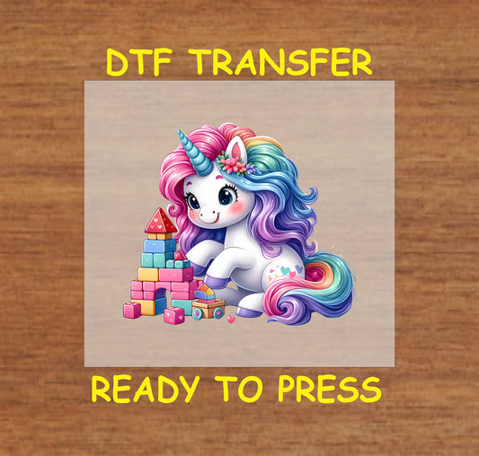 Cute rainbow unicorn playing with colorful blocks DTF transfer.