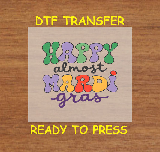 DTF transfer with colorful text reading "Happy Almost Mardi Gras."