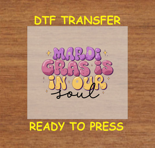 DTF transfer with "Mardi Gras Is in Our Soul" in bold, colorful bubble-style letters.