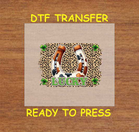 St. Patrick’s Day DTF transfer with a cow print horseshoe, leopard background, and shamrocks.