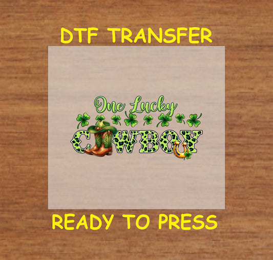 St. Patrick’s Day DTF transfer featuring "One Lucky Cowboy" text with a cowboy boot, hat, shamrocks, and horseshoe.