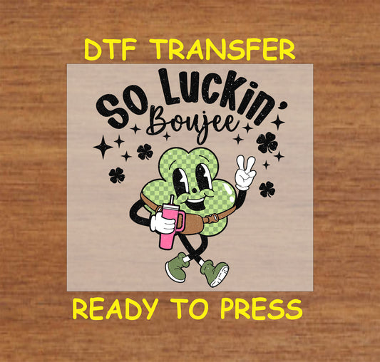 St. Patrick’s Day kids DTF transfer with a stylish shamrock character, tumbler, and crossbody bag, featuring the phrase “So Luckin’ Boujee.”