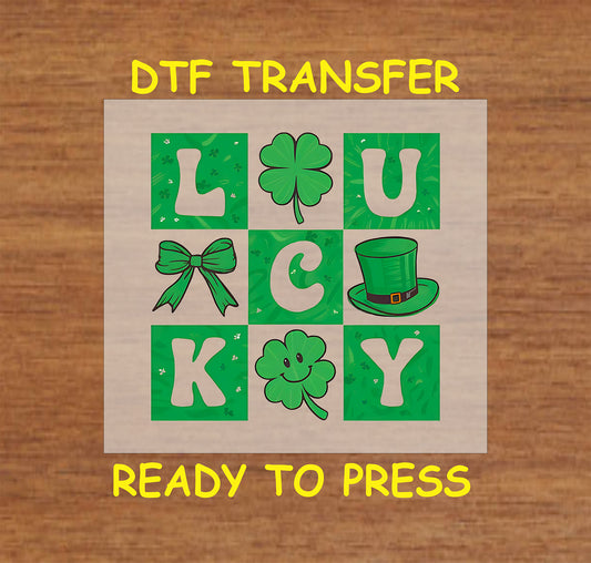 Lucky block letters St. Patrick’s Day DTF transfer with shamrocks, bow, and leprechaun hat.