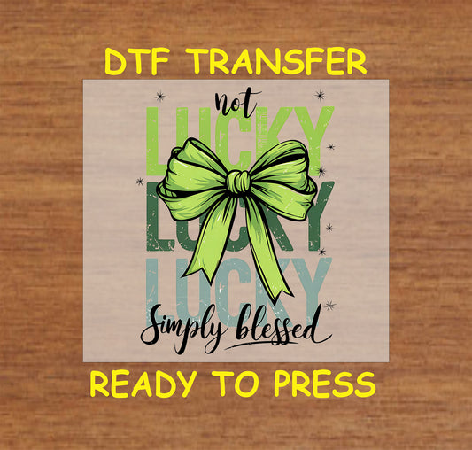 Not Lucky Simply Blessed St. Patrick’s Day DTF transfer with green bow and distressed text.