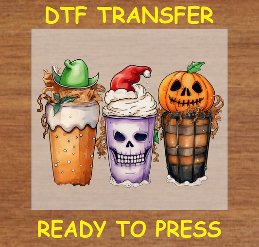 Three festive drink cups: skull with Santa hat, pumpkin, and elf hat, in a fall and Halloween-themed DTF transfer.