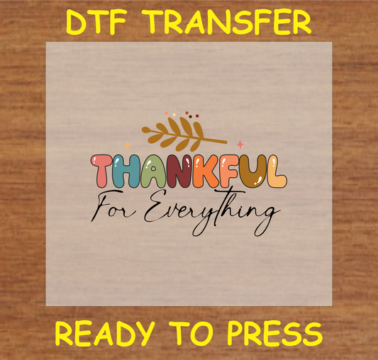 "Thankful for Everything" DTF transfer with multicolored letters and autumn leaf accents, ready to press.