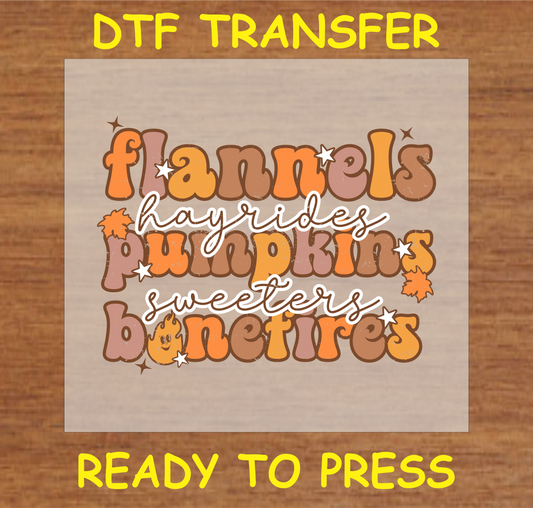 "Flannels, Hayrides, Pumpkins, and Bonfires" DTF transfer with colorful autumn-themed text design.