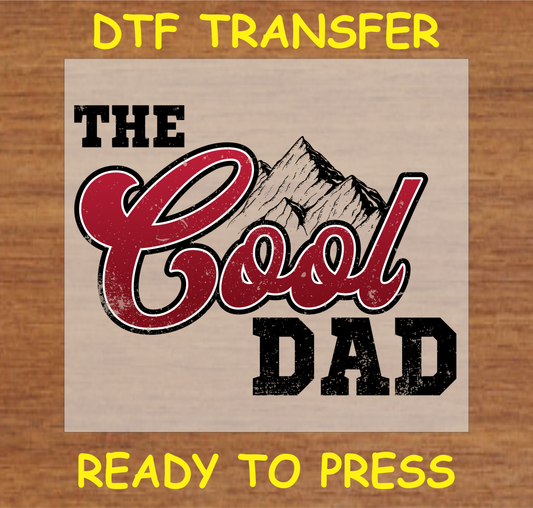 DTF transfer featuring the text 'The Cool Dad' with bold lettering and a rugged mountain graphic, perfect for custom apparel.