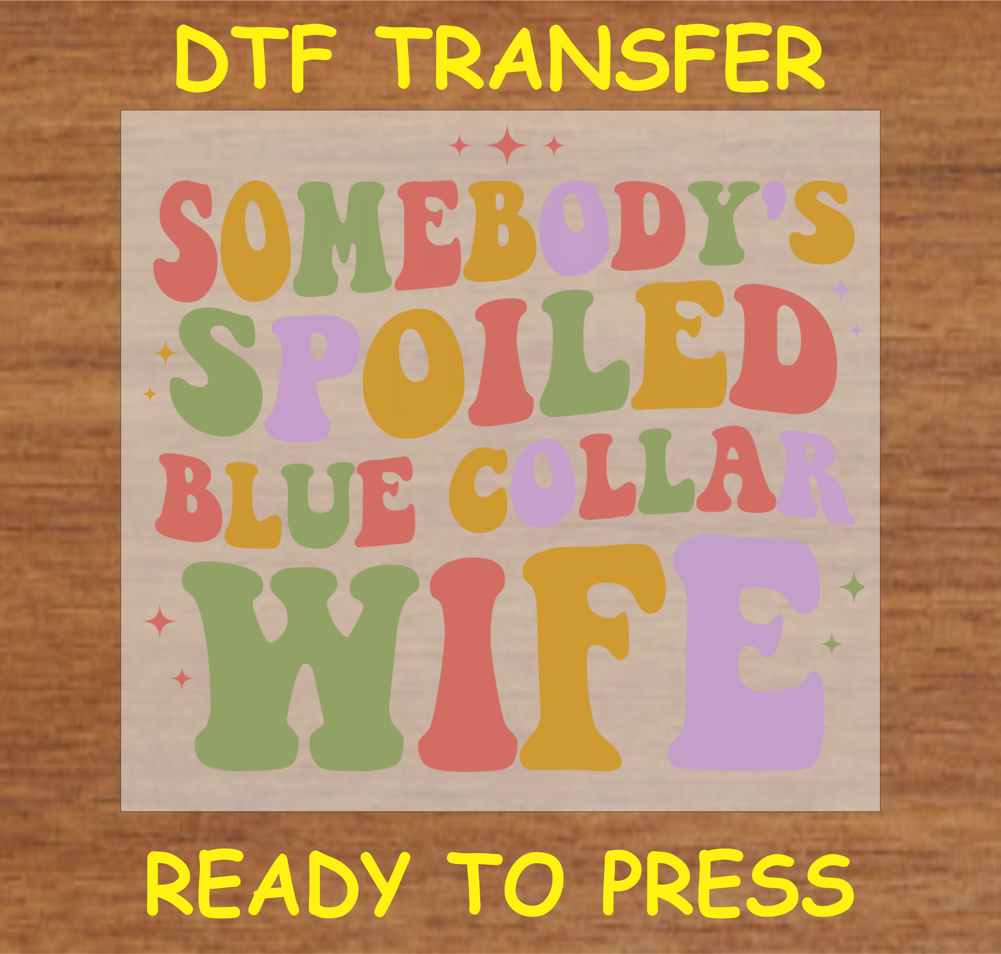 DTF transfer featuring the text 'Somebody's Spoiled Blue Collar Wife' in colorful retro-style lettering, perfect for custom apparel.