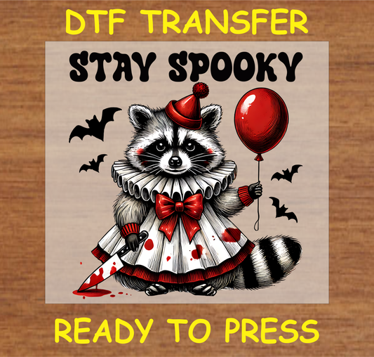 DTF transfer design featuring an animal in a spooky clown costume, holding a red balloon and knife, with the text "Stay Spooky."