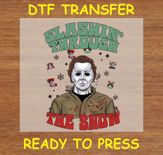 DTF Transfer featuring a horror character with the text "Slashin' Through the Snow" and festive Christmas elements, perfect for custom holiday apparel.