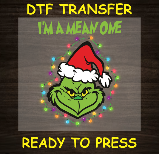 DTF transfer featuring a Grumpy Green character in a Santa hat surrounded by Christmas lights with the text "I'm a Mean One."