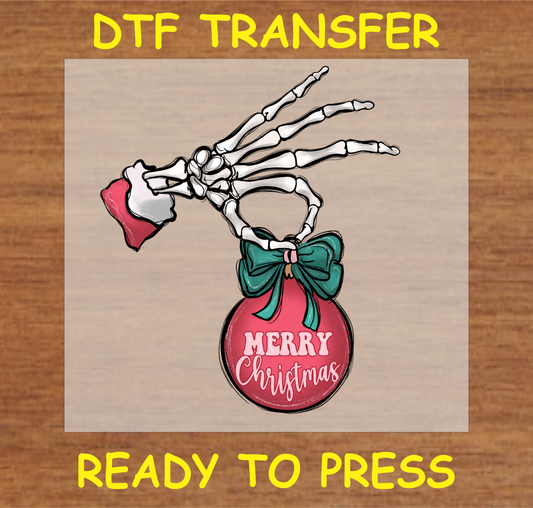 DTF transfer design featuring a skeleton hand holding a Christmas ornament with the text "Merry Christmas."