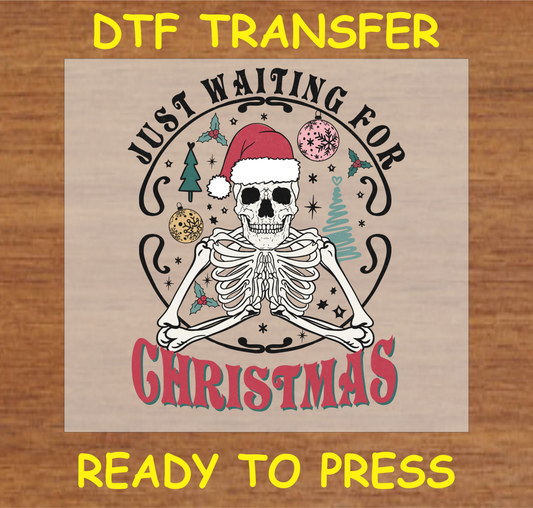 DTF transfer design featuring a skeleton in a Santa hat surrounded by Christmas ornaments with the text "Just Waiting for Christmas."